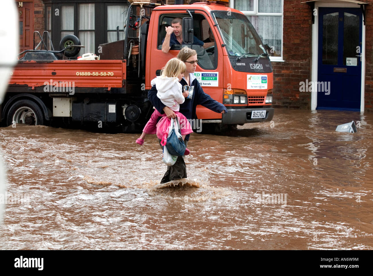 Femme portant son enfant par les inondations dans la région de Tenbury Wells Juin 2007 Banque D'Images