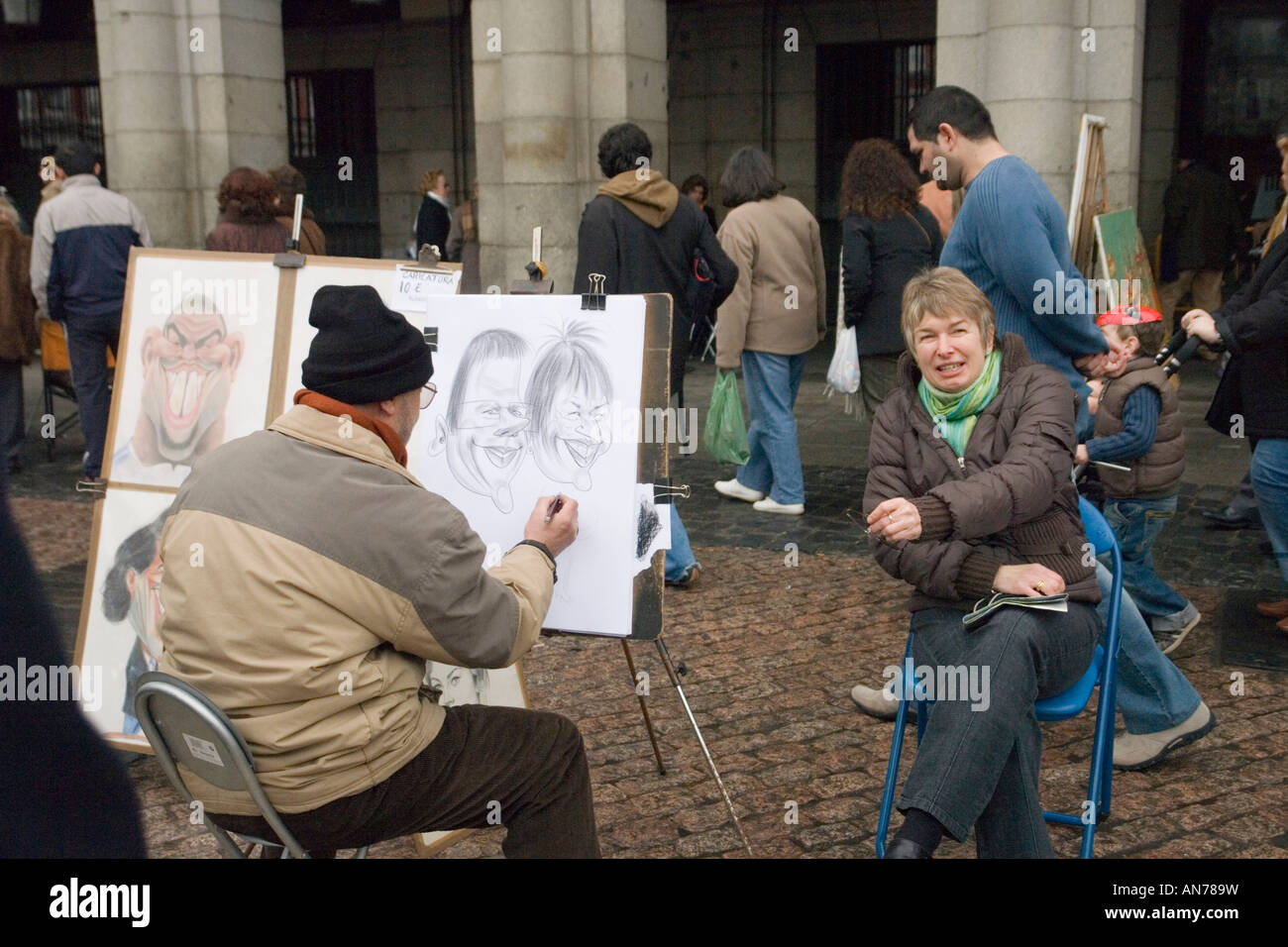 À Madrid, un caricaturiste de rue et le modèle sur la Plaza Mayor (Espagne). Artiste des rues et son modèle, à Madrid (Espagne). Banque D'Images