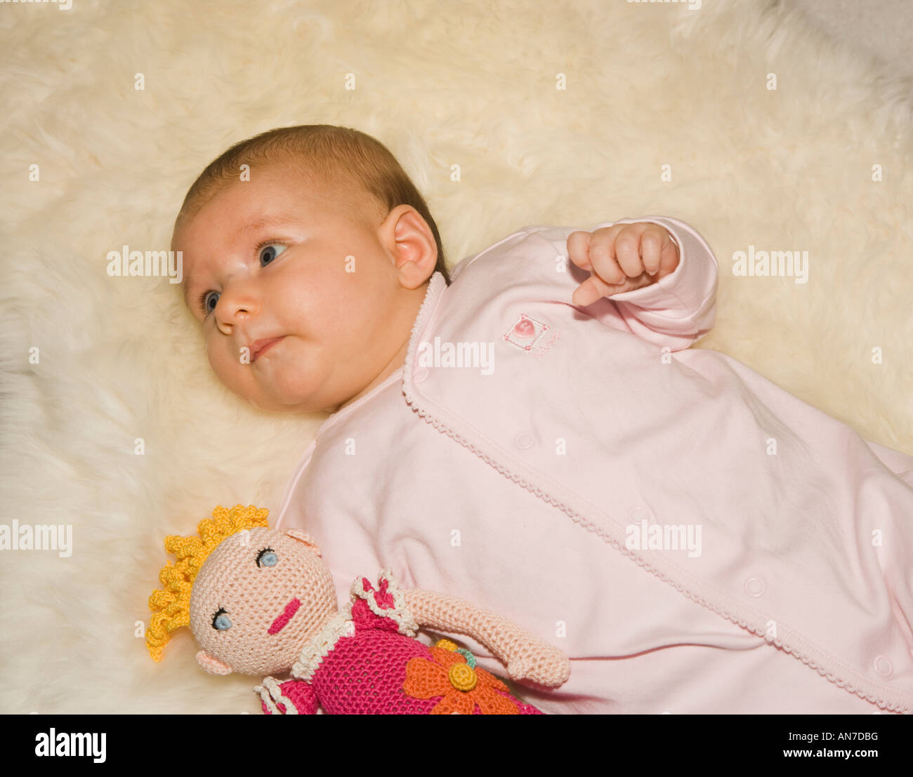 Trois mois bébé couché sur un tapis à la poupée Banque D'Images