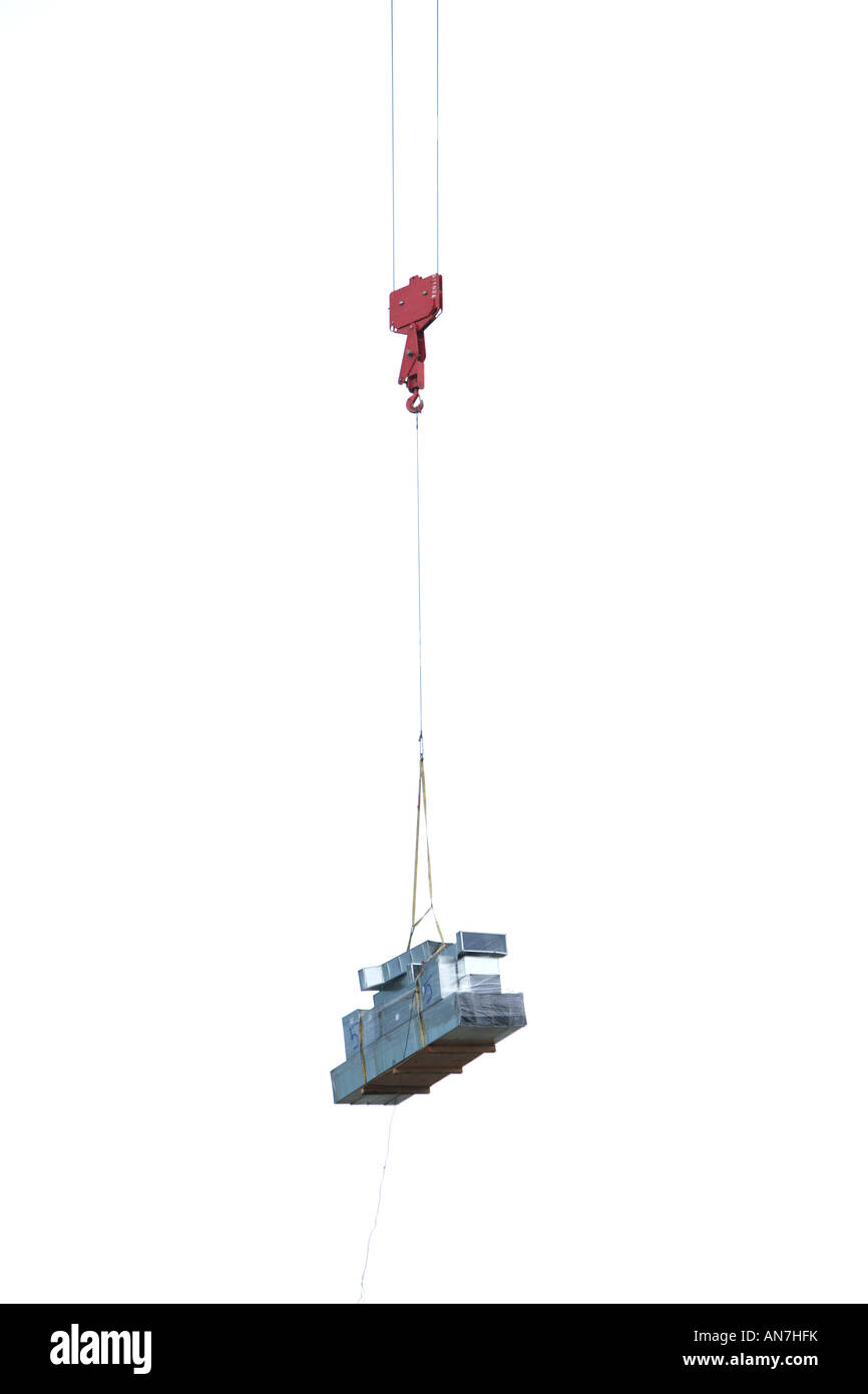 Un crain sur un site de construction mécaniques des matériaux de construction au sommet d'un racleur de ciel Banque D'Images