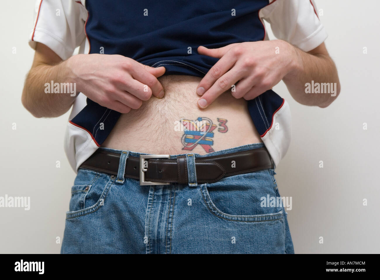 La mi-section de l'homme montrant tatouage sur son ventre Banque D'Images