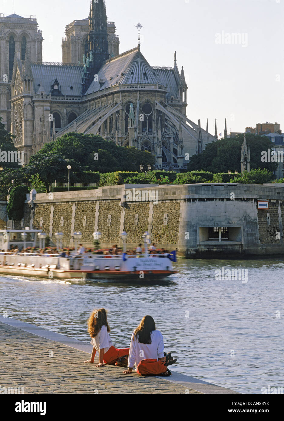 Deux femmes se détendre près de l'Ile St Louis sur Seine aux bateaux de passer en dessous de Notre Dame Paris holiday Banque D'Images