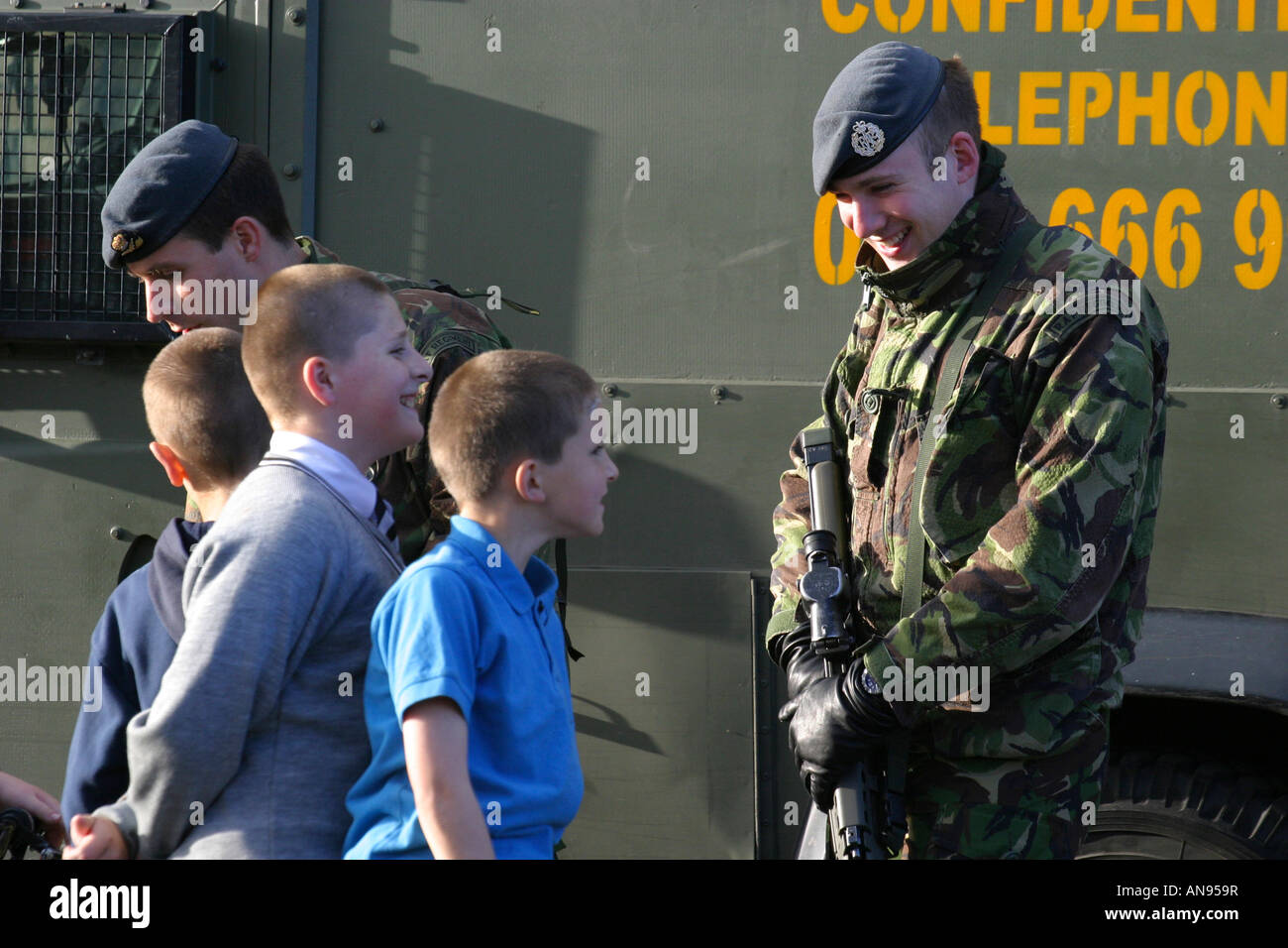 Les soldats de l'armée britannique RAF regiment discuter avec les garçons de Belfast lors de cœur et l'esprit au cours de la tournée de campagne north parade Banque D'Images