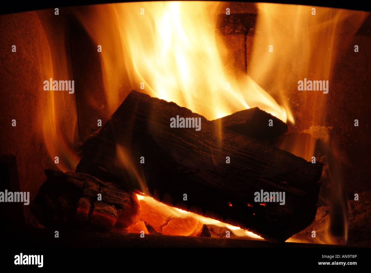 Flammes à travers la vitre d'un poêle à bois Banque D'Images