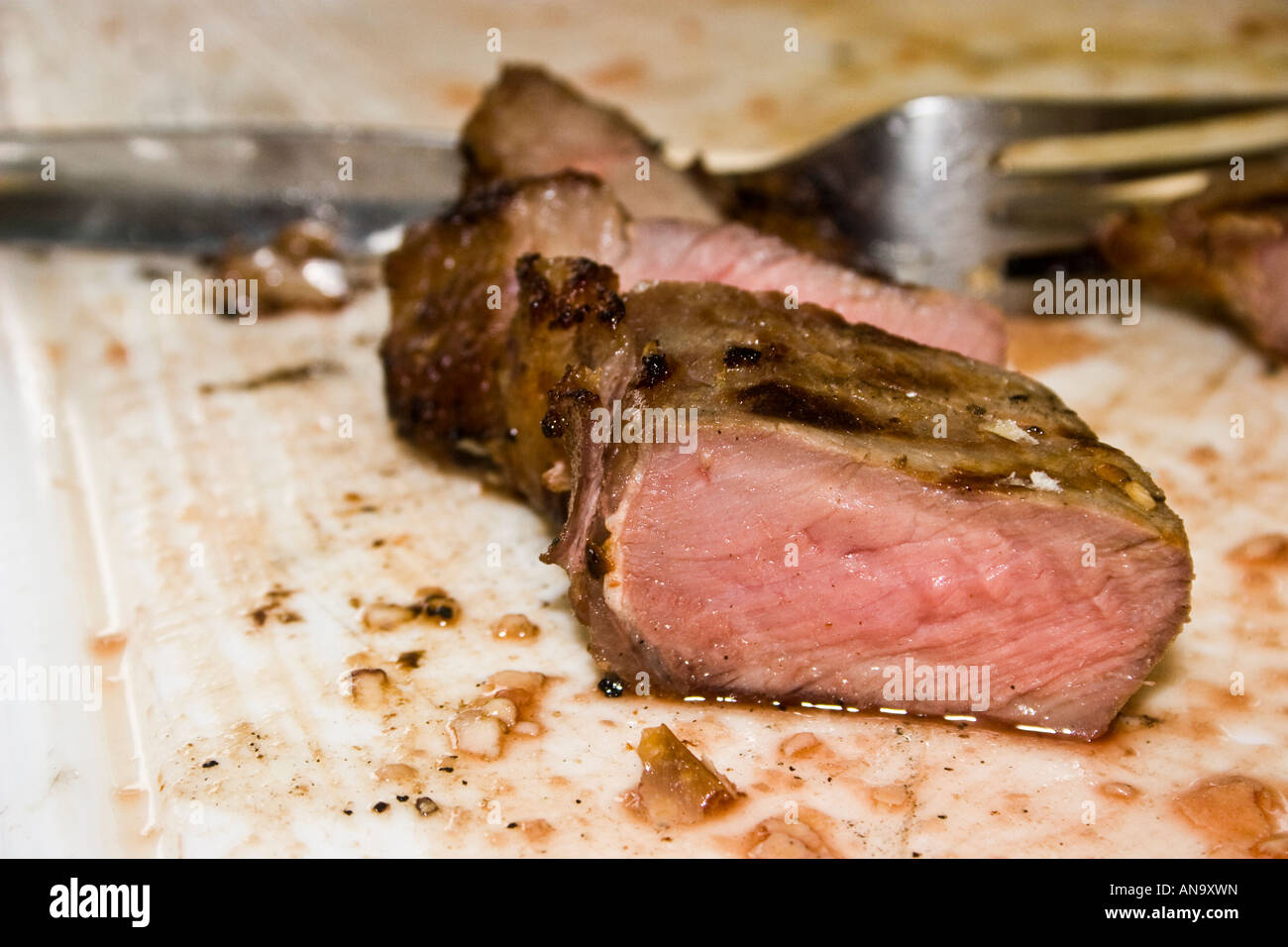 Une coupe de viande sur une planche à découper, une fourchette dans l'arrière-plan Banque D'Images
