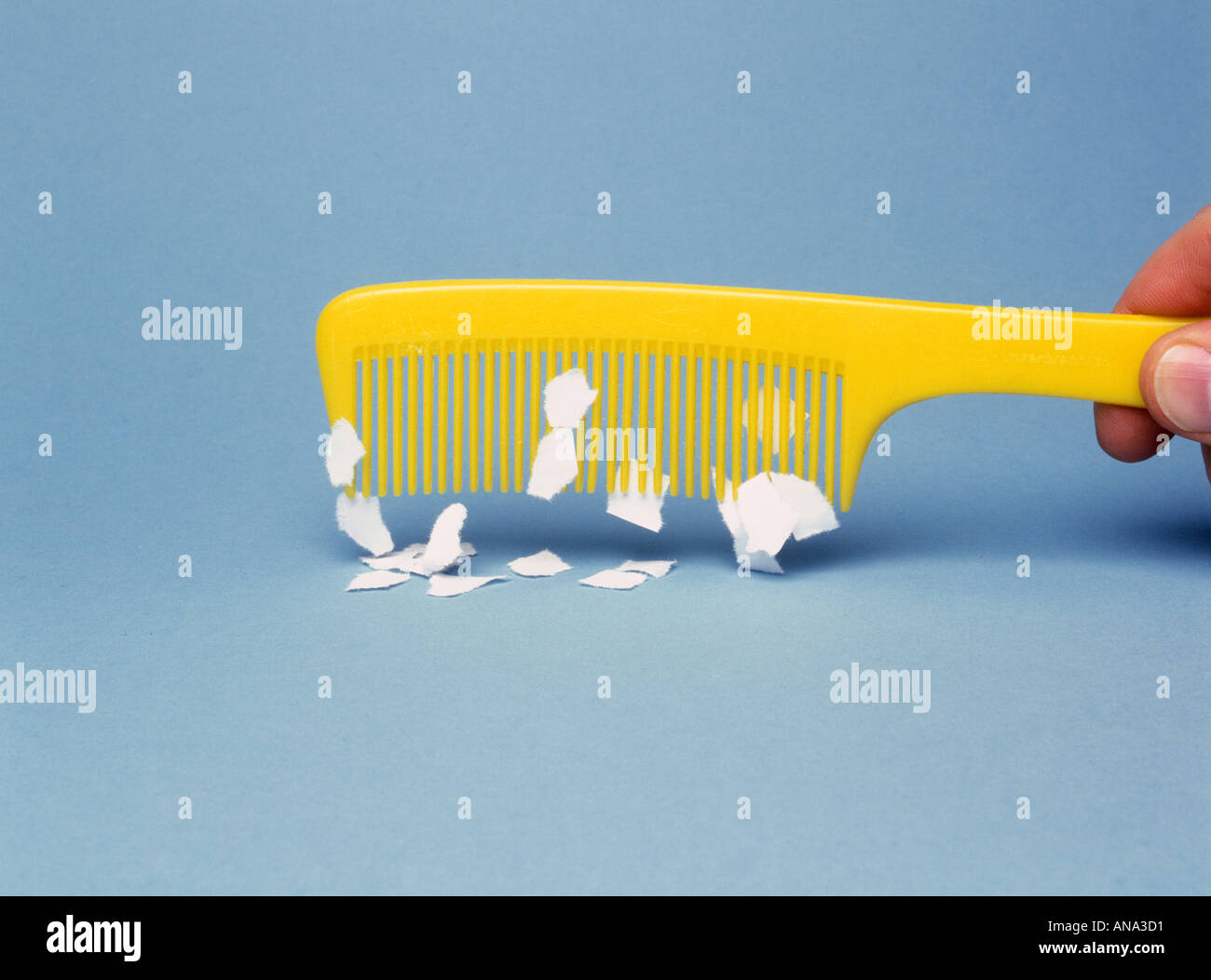 L'électricité statique sur comb attire des morceaux de papier Banque D'Images