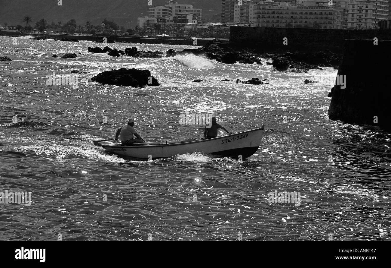 Deux hommes dans un petit bateau de pêche avec moteur hors-bord en mer près de Puerto De La Cruz à Tenerife Banque D'Images