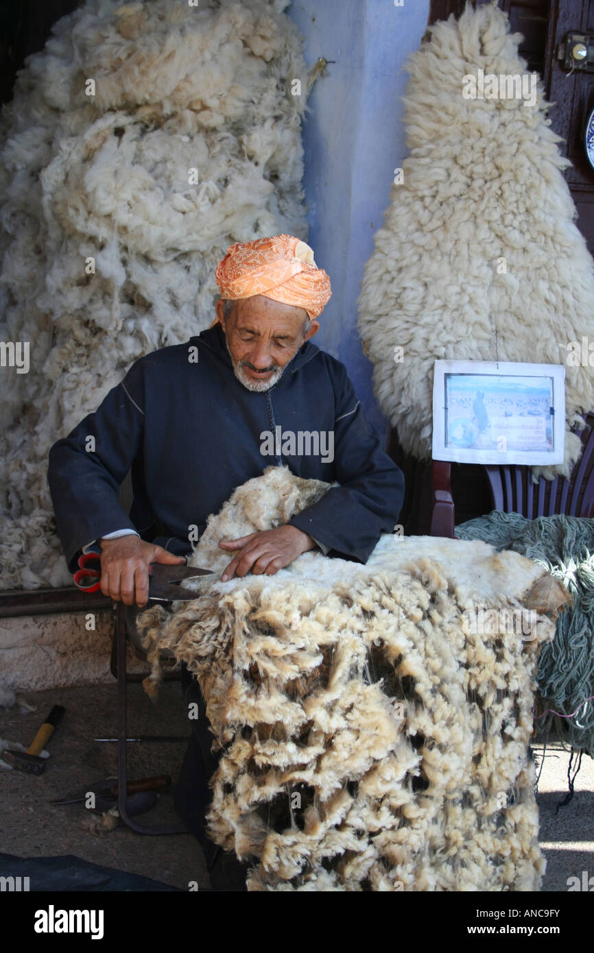 Homme berbère travaillant avec une toison de brebis dans un souk, Meknès, Maroc, Afrique du Nord Banque D'Images