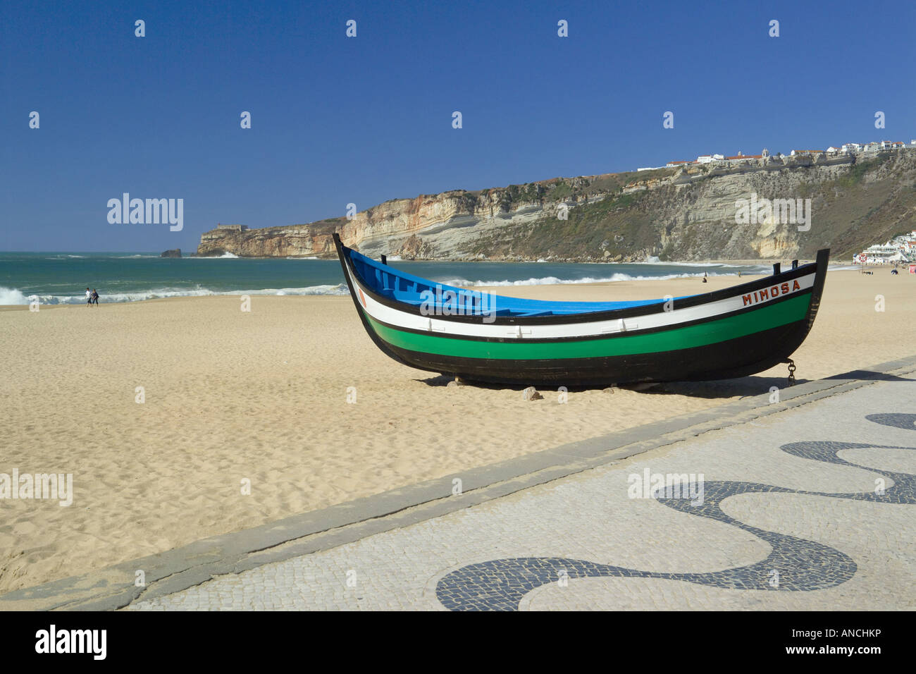 Au Portugal, la Costa da Prata, la plage de Nazaré, un bateau de pêche et de la chaussée pavée décorée typiquement portugais sur la promenade Banque D'Images