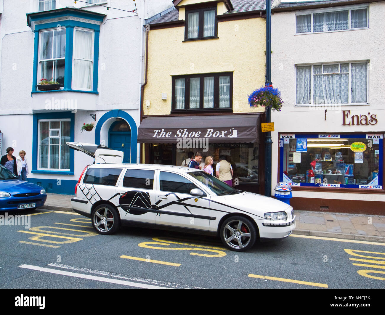White Estate Volvo voiture garée dans la rue principale au nord du Pays de Galles Royaume-uni Beaumaris Anglesey du roulement de l'araignée noire inhabituelle et motif web Banque D'Images