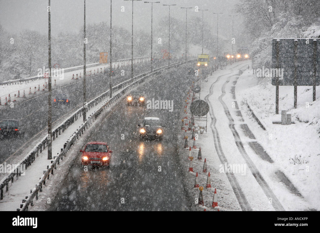 Voitures dans la conduite le long de l'autoroute M2 en dehors de Belfast lors d'une forte tempête de neige Banque D'Images
