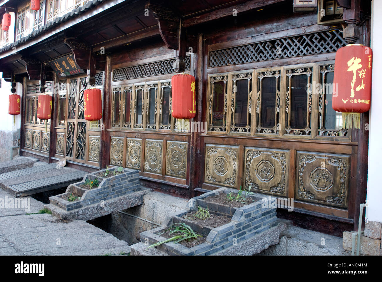 Lanternes rouges ornent un restaurant en bois dans la région de Lijiang, Yunnan, Chine situé à côté d'un ruisseau, en donnant à la ville son titre:Venise de Chine Banque D'Images