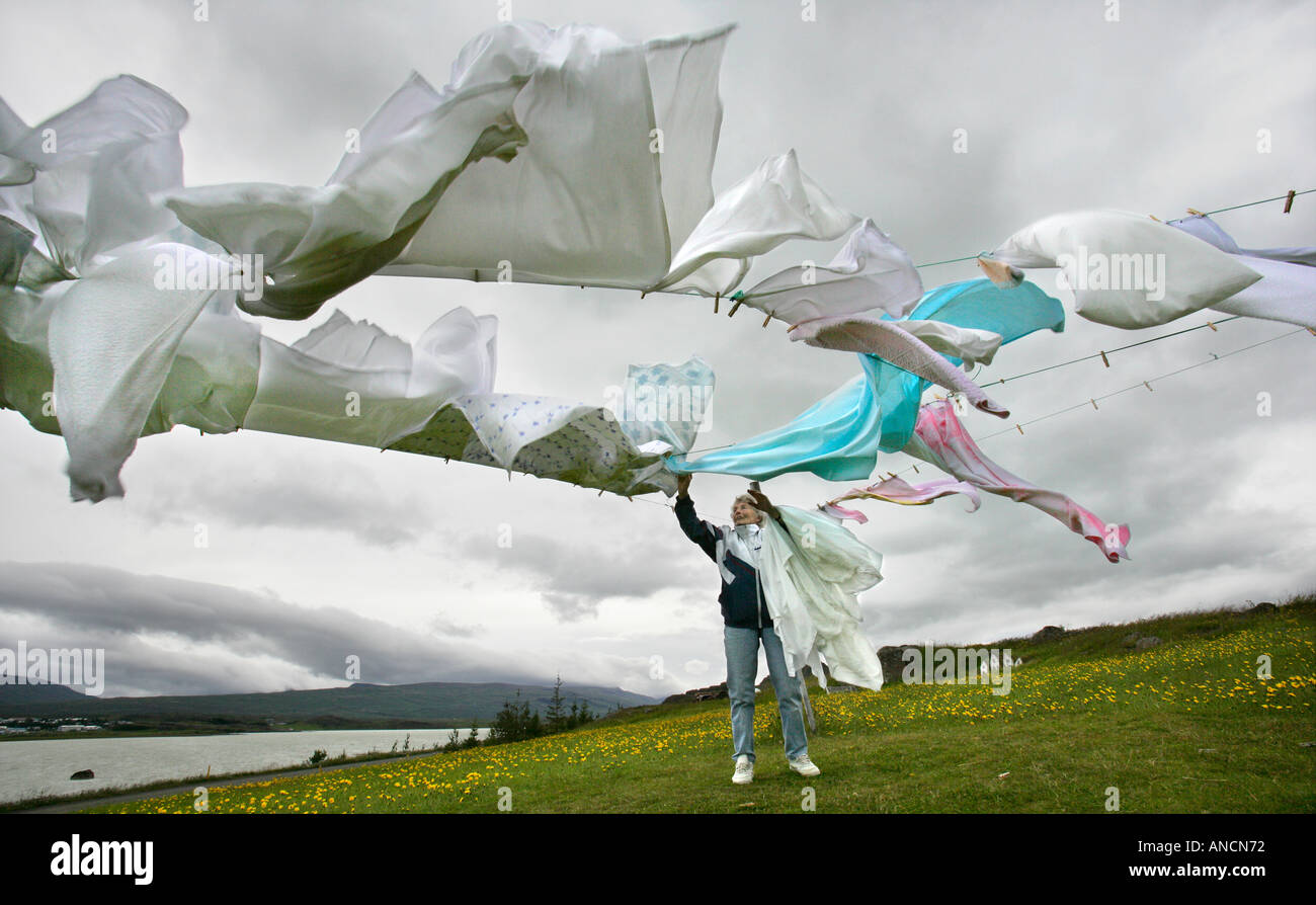 Femme étendre le linge dans le vent sur la ligne de vêtements d'Egilsstadir Islande Banque D'Images