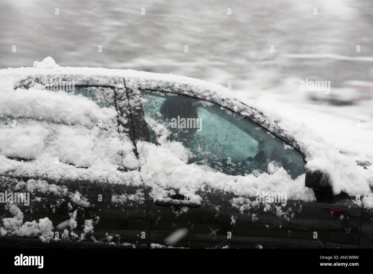 Excès de voiture passé avec des fenêtres partiellement recouvert de neige durant tempête Banque D'Images