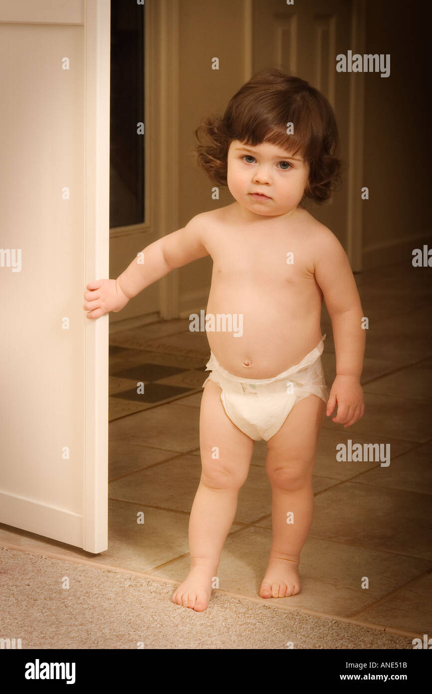 Petite fille en couches holding porte ouverte Photo Stock - Alamy