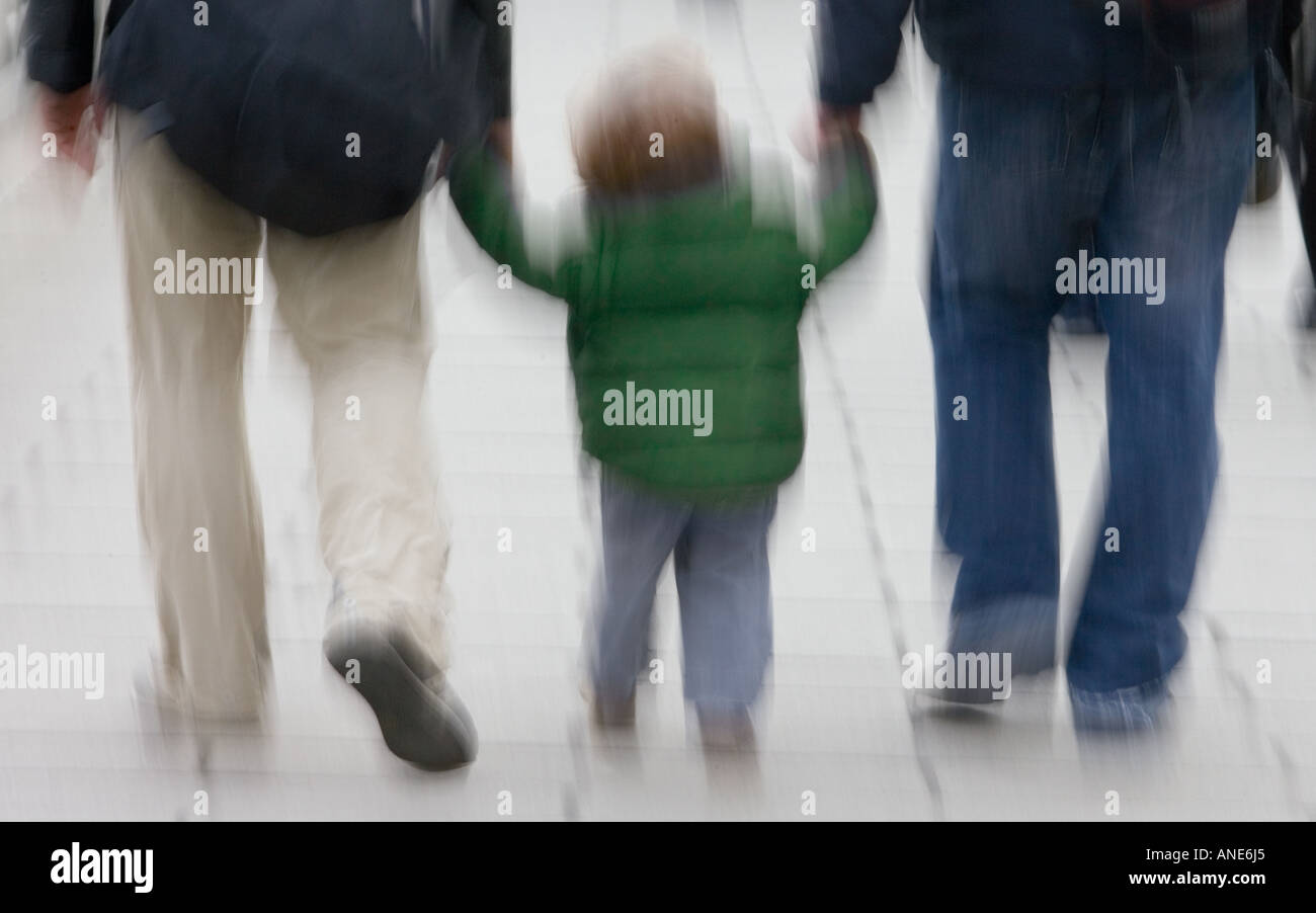 Adultes tenir une main d'enfant comme ils marchent à travers Londres Angleterre Royaume-Uni Banque D'Images