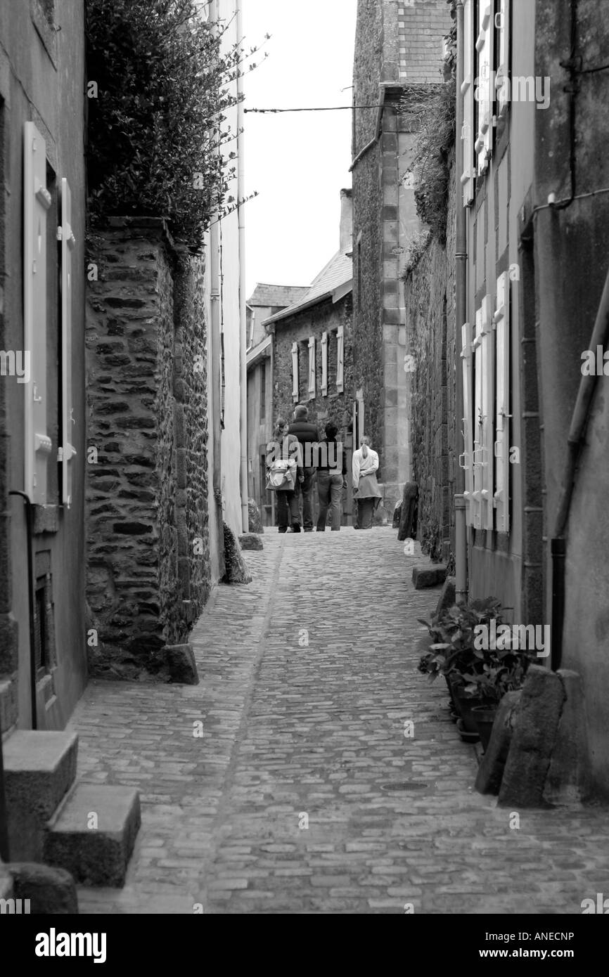 Une jeune famille marchant le long d'une rue médiévale française norrow dans la Haute Ville de Granville La Manche Normandie France Banque D'Images