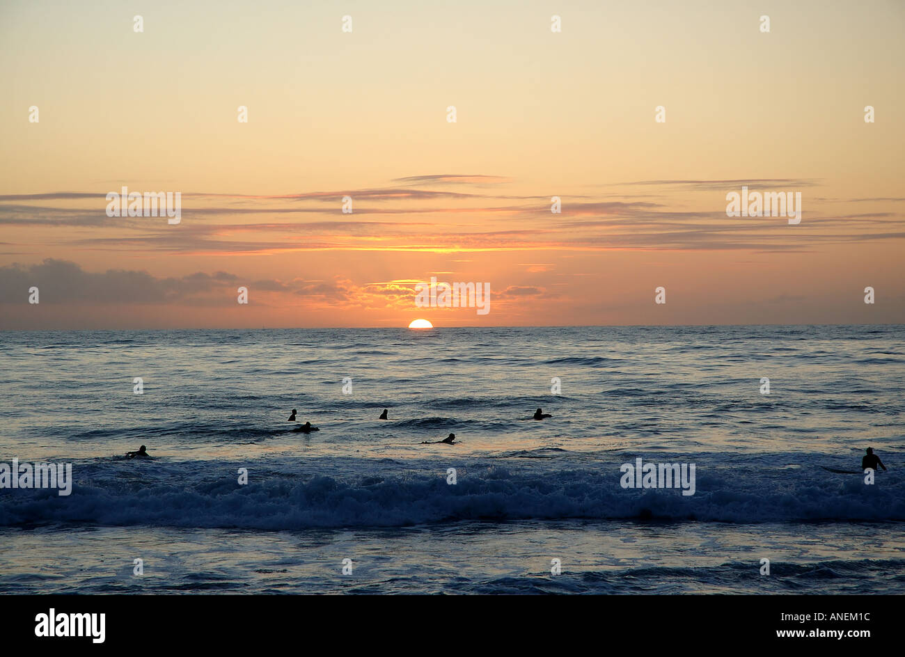 Surfers silhouetted par coucher de soleil sur l'Océan Indien, l'Australie occidentale Perth City Beach Banque D'Images