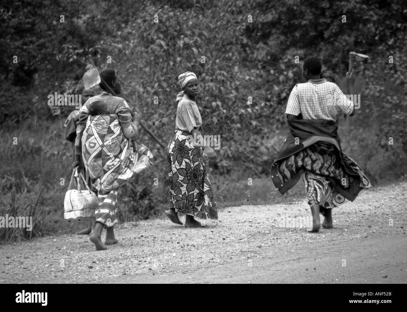 Les jeunes femmes en costume traditionnel transporter sur les épaules de l'enfant marche pied nu à Katuna Byumba Rwanda Afrique de l'Est Banque D'Images