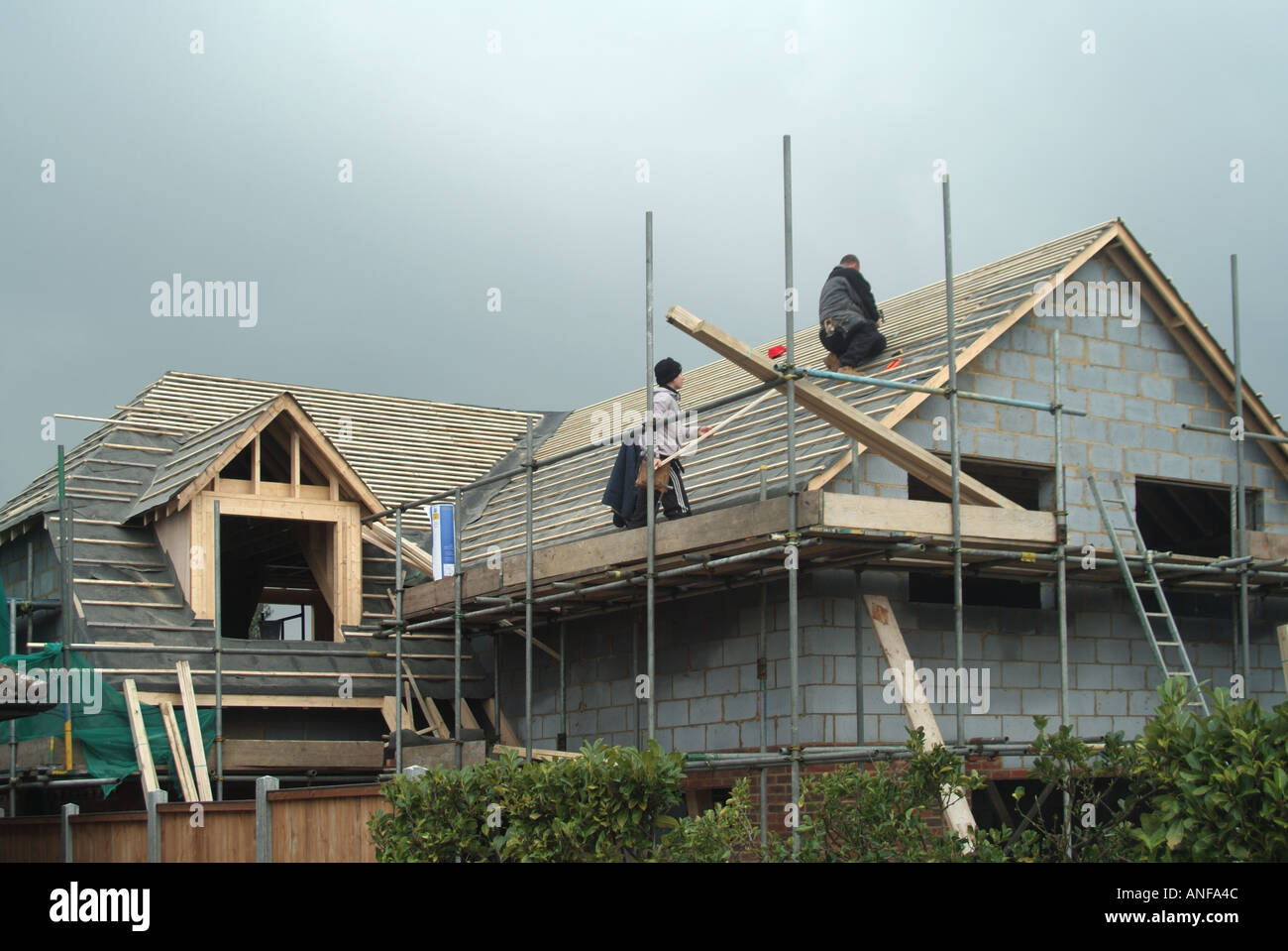 Maison individuelle en construction couvreurs tuile fixation charpente pour recevoir des carreaux ordinaire Banque D'Images