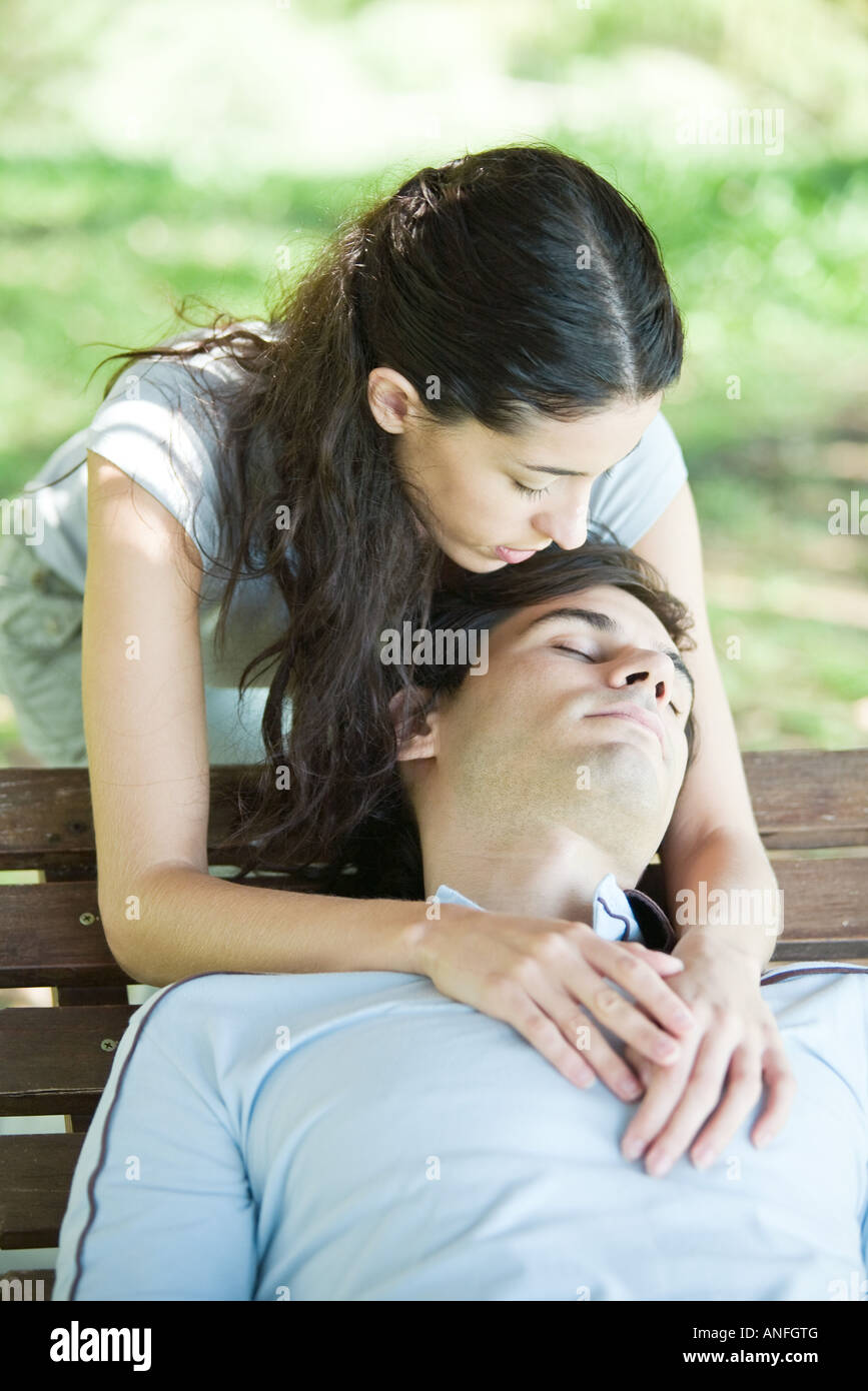 Jeune couple, l'homme de dormir sur banc de la femme tout en bras autour de  lui par derrière Photo Stock - Alamy