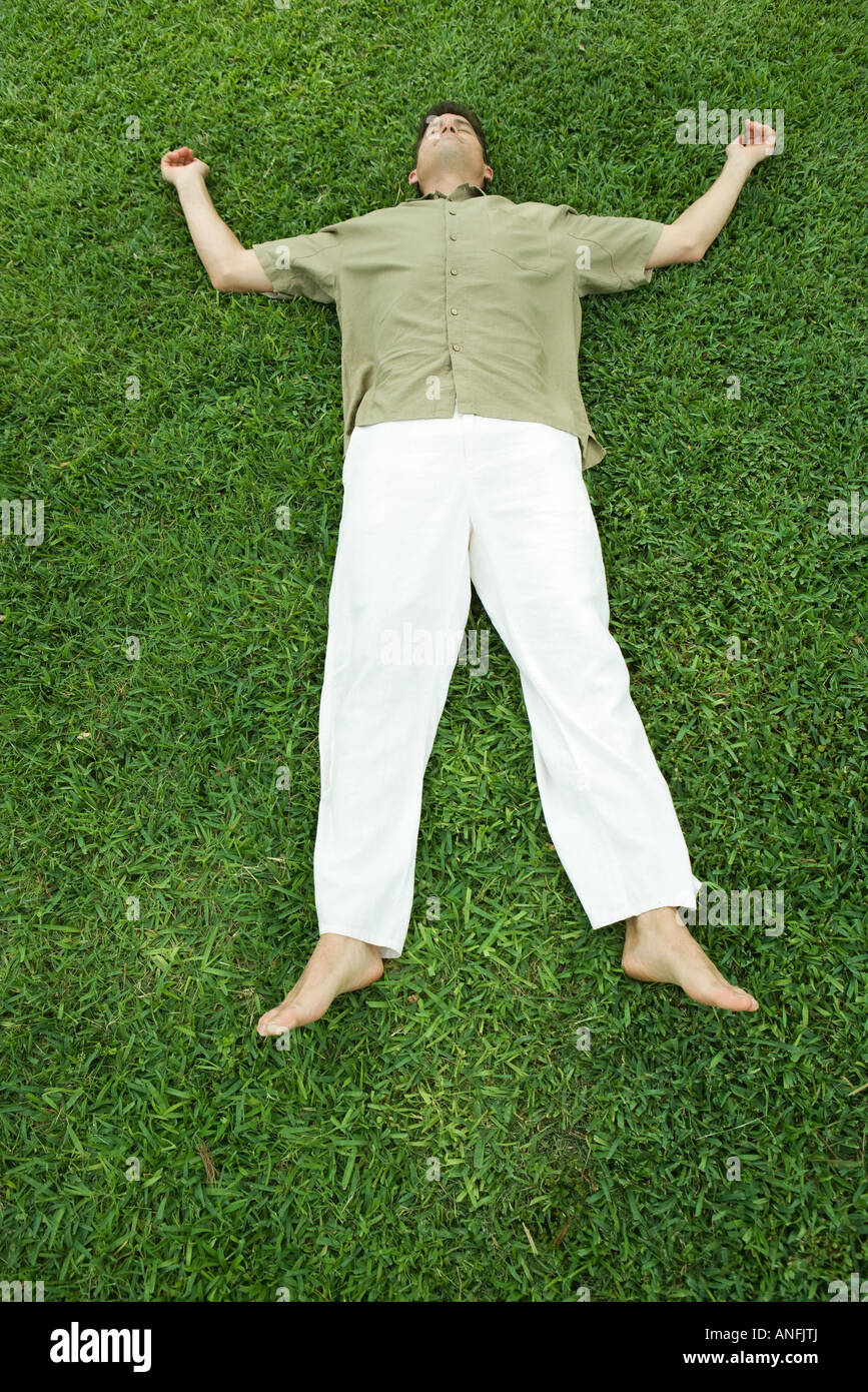 Man lying on grass, pleine longueur Banque D'Images