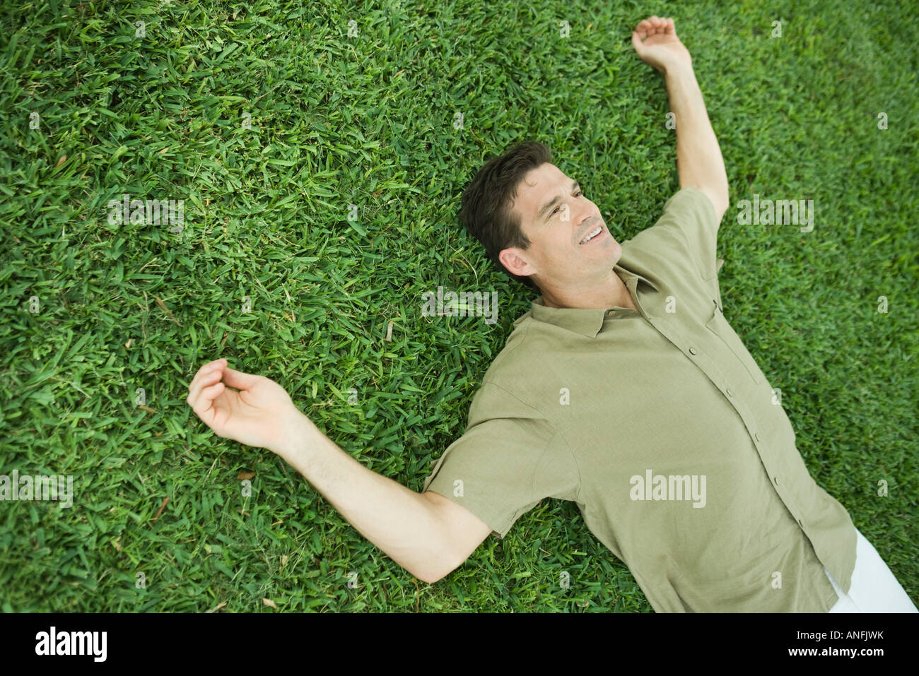 Man lying on grass, smiling Banque D'Images