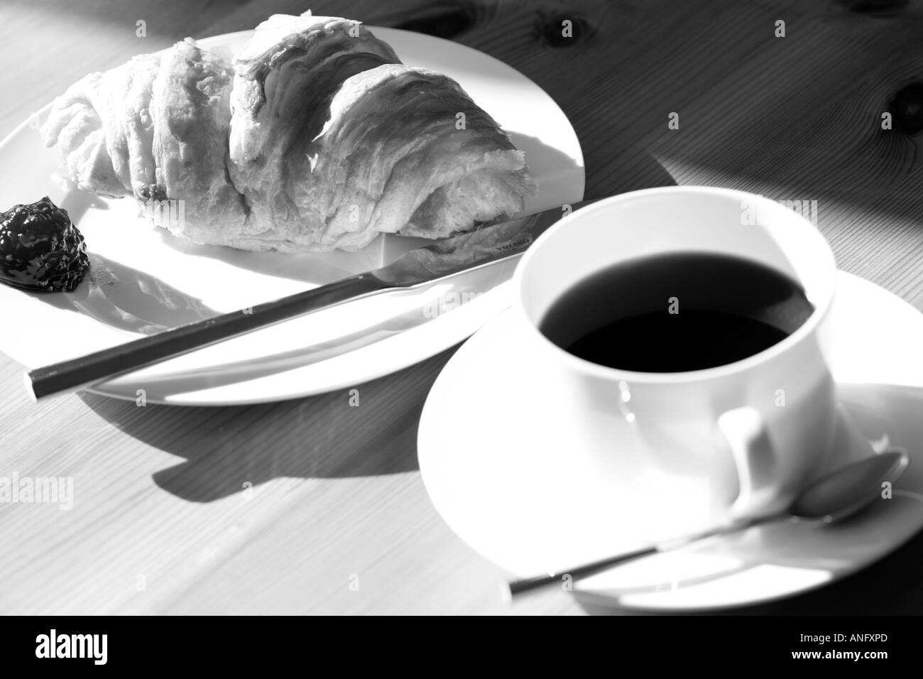 Close up de croissant et dans la tasse de café du matin - horizontal tourné en noir et blanc Banque D'Images