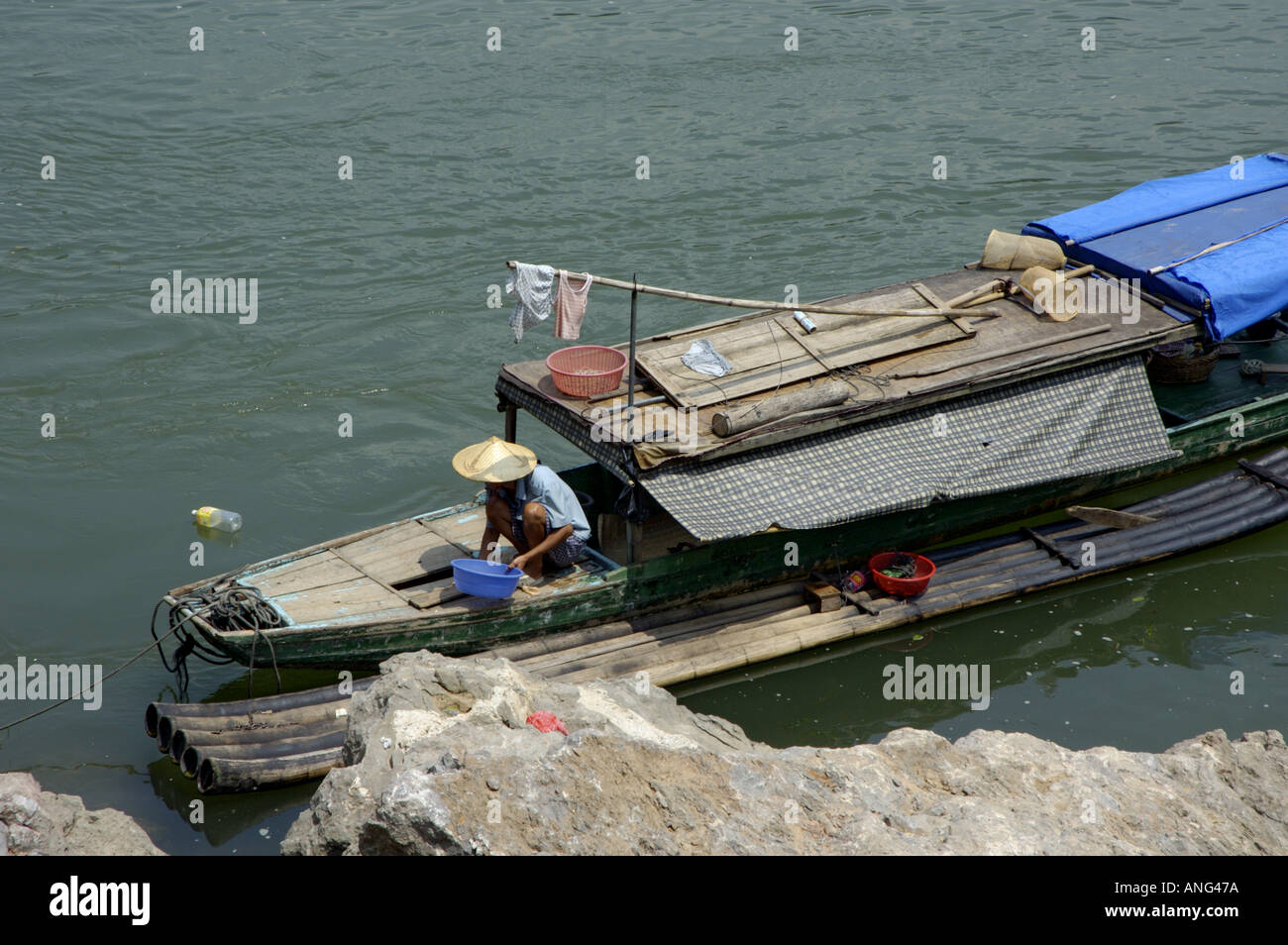 Chine Guangxi homme sur son bateau sur la rivière Li Jiang entre Xinping et Yangshuo Banque D'Images