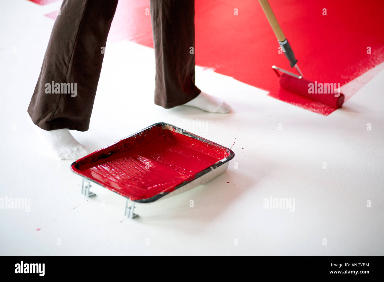 31 ans femme italienne peinture rouge sur un mur blanc dans un loft, Montréal, Québec, Canada. Banque D'Images