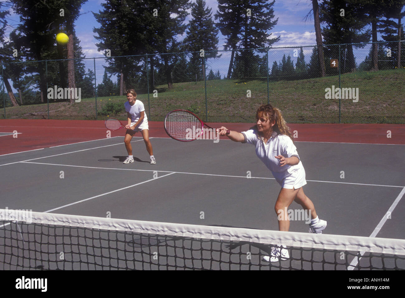 Deux femmes jouant au tennis en double, 108 Mile Rd, British Columbia, Canada. Banque D'Images