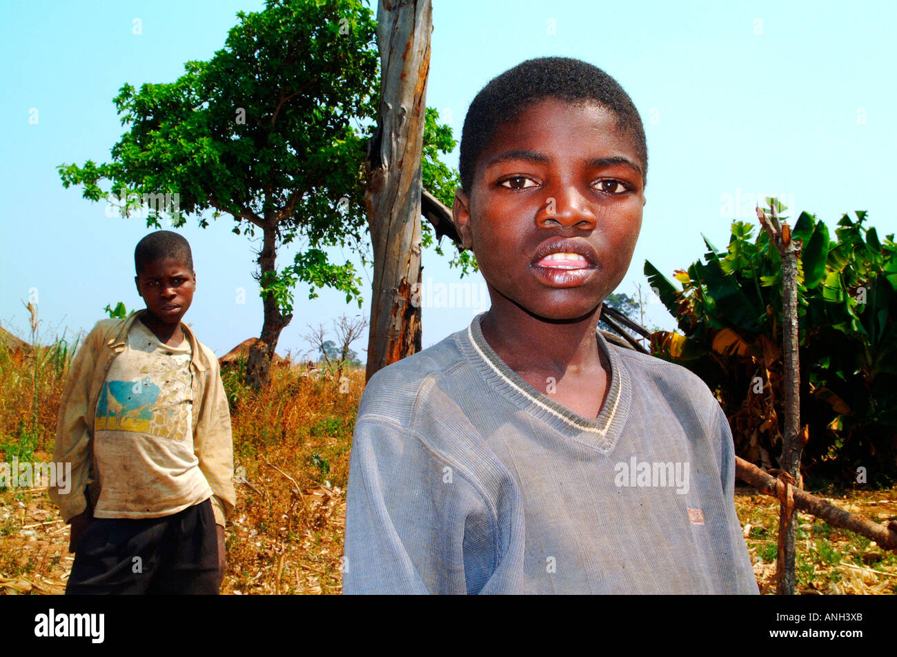 Deux garçons africains de l'Angola, l'un à l'avant-plan et l'un à l'arrière-plan, ce qui concerne le photographe avec intérêt. Banque D'Images