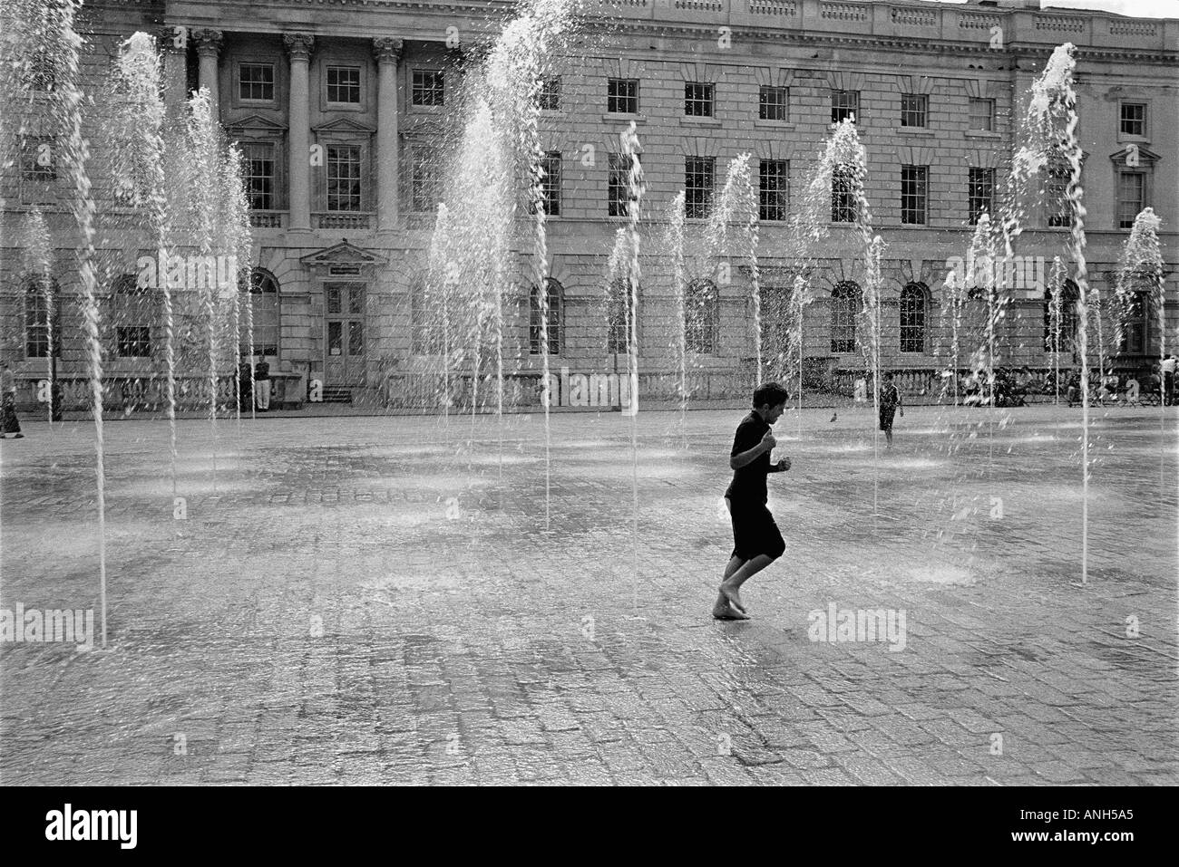 Garçon traversant une fontaine à Summersethouse , Londres , Royaume-Uni Banque D'Images