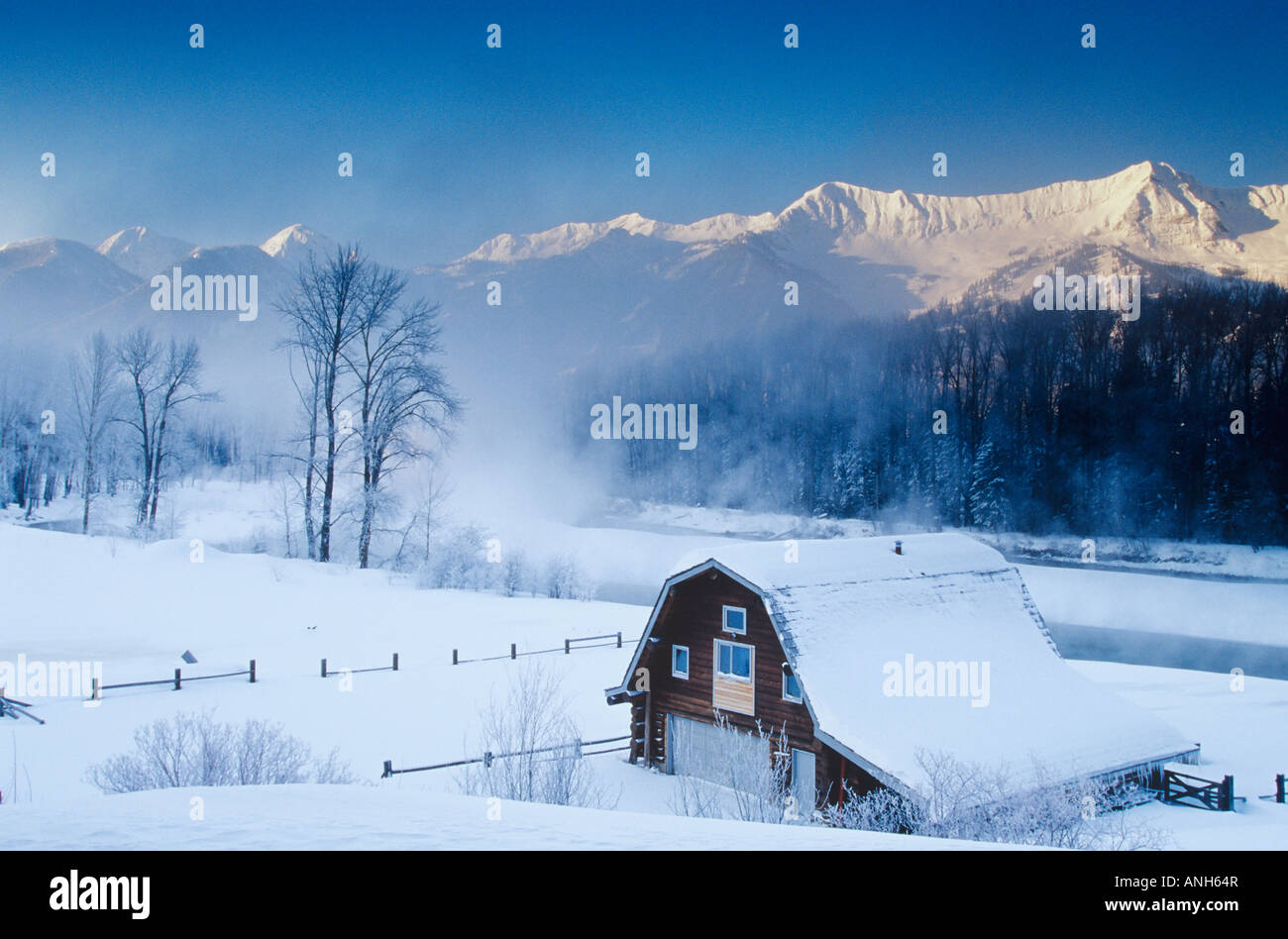 Ancienne grange et Elk River en hiver avec Fernie Alpine Resort et Lizard Range en arrière-plan, de Fernie, en Colombie-Britannique, Canada. Banque D'Images