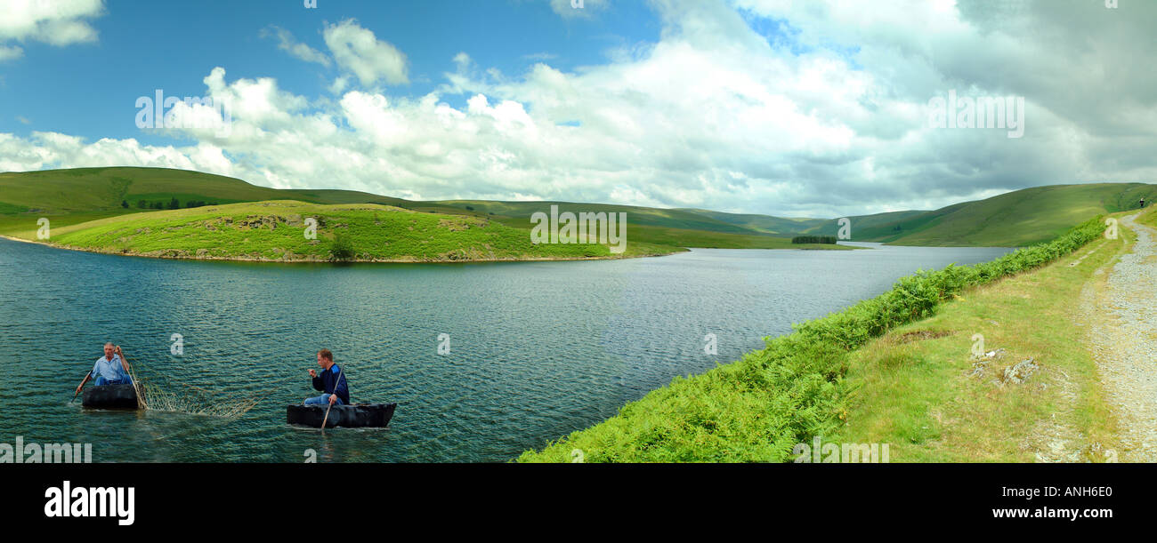 La pêche au filet à l'aide de deux coracles sur un lac au Pays de Galles Banque D'Images