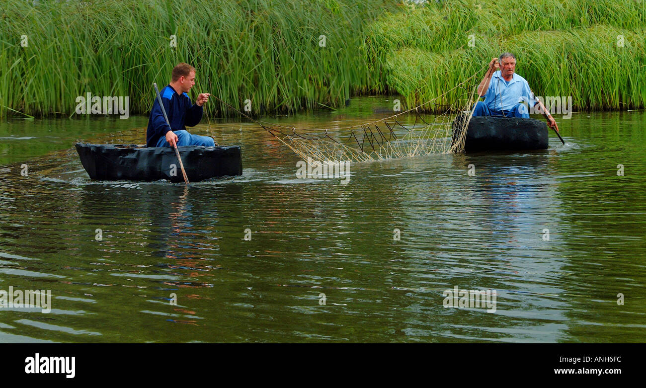 La pêche au filet à l'aide de deux coracles sur un lac au Pays de Galles Banque D'Images