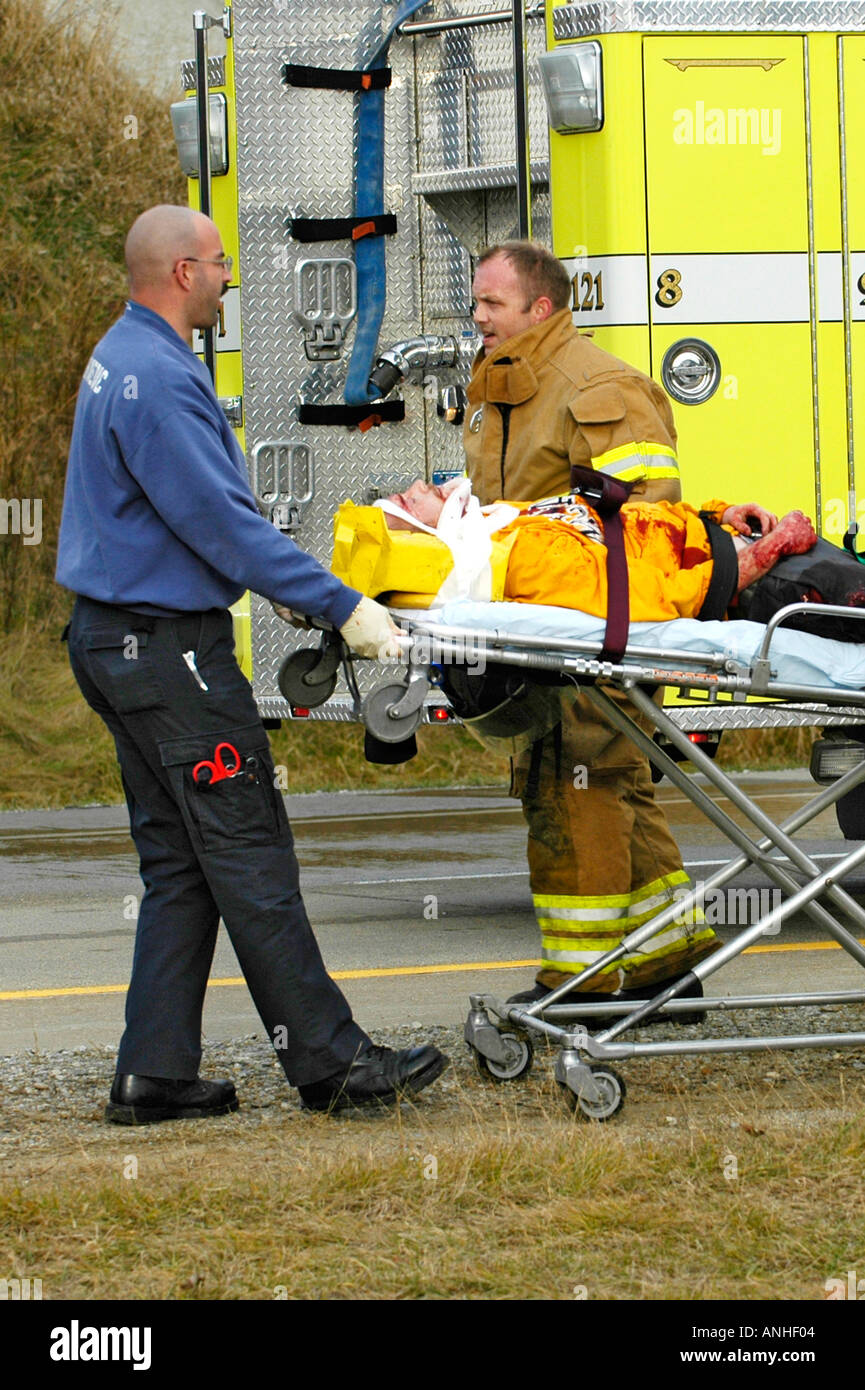 Les pompiers blessés à assister à l'égard des victimes d'accidents d'un chef sur l'accident automobile Banque D'Images