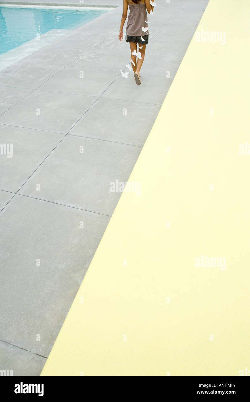 Adolescente marchant à côté piscine exerçant son streamer papillon, cropped vue arrière Banque D'Images