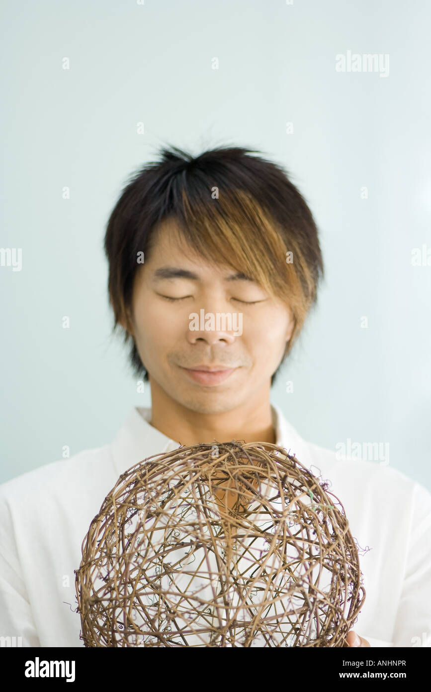 Man holding sphère, les yeux fermés Banque D'Images