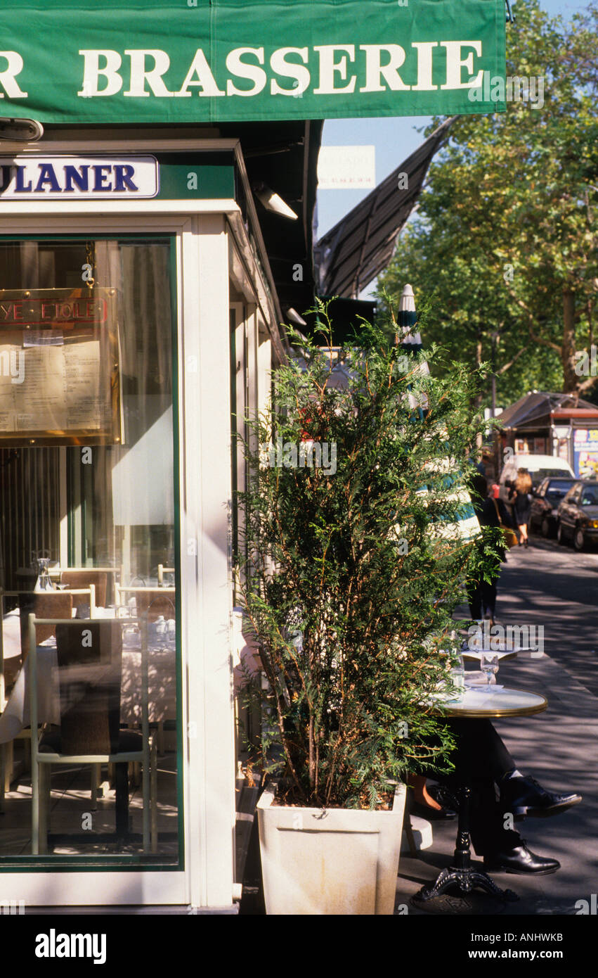 Europe France Paris Un homme assis à une table dans la rue en dehors d'une brasserie Banque D'Images