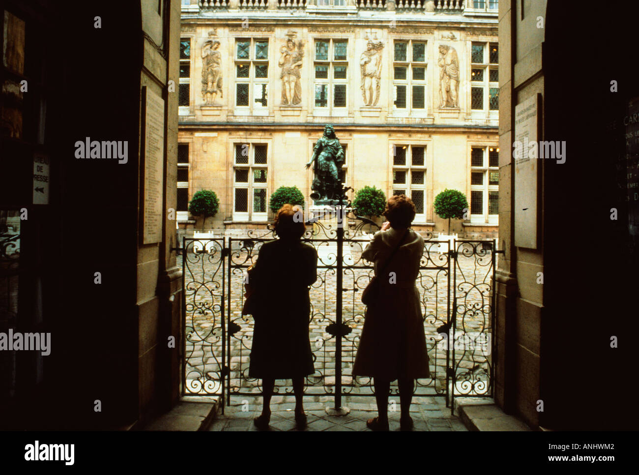 Europe France Paris le quartier du Marais deux femmes regardant la cour du Musée Carnavalet. Musée dédié à l'histoire de Paris. Banque D'Images