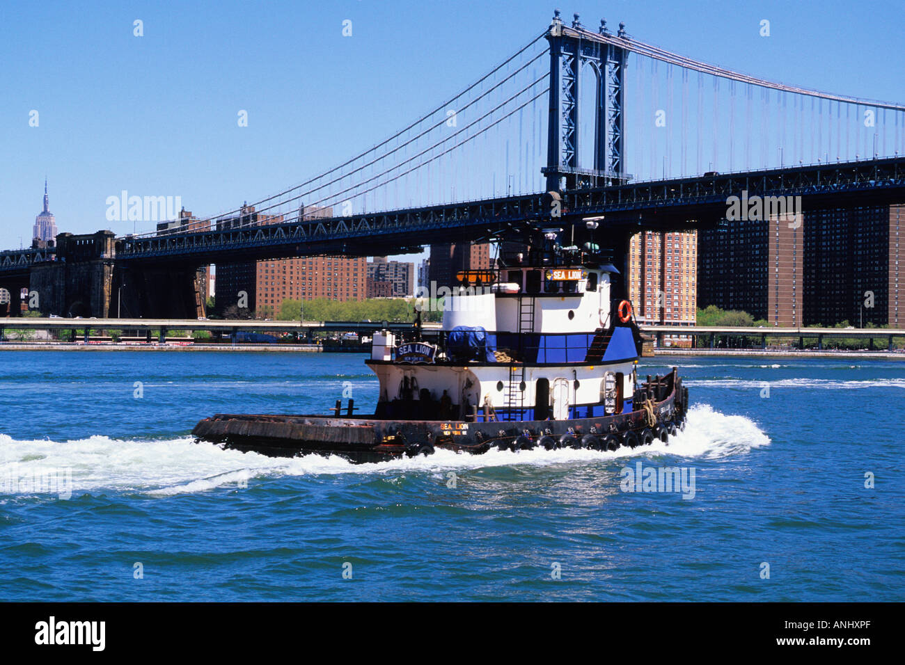 Remorqueurs ou remorqueurs et le pont de Manhattan dans la rivière East, New York. Empire State Building au loin. ÉTATS-UNIS Banque D'Images