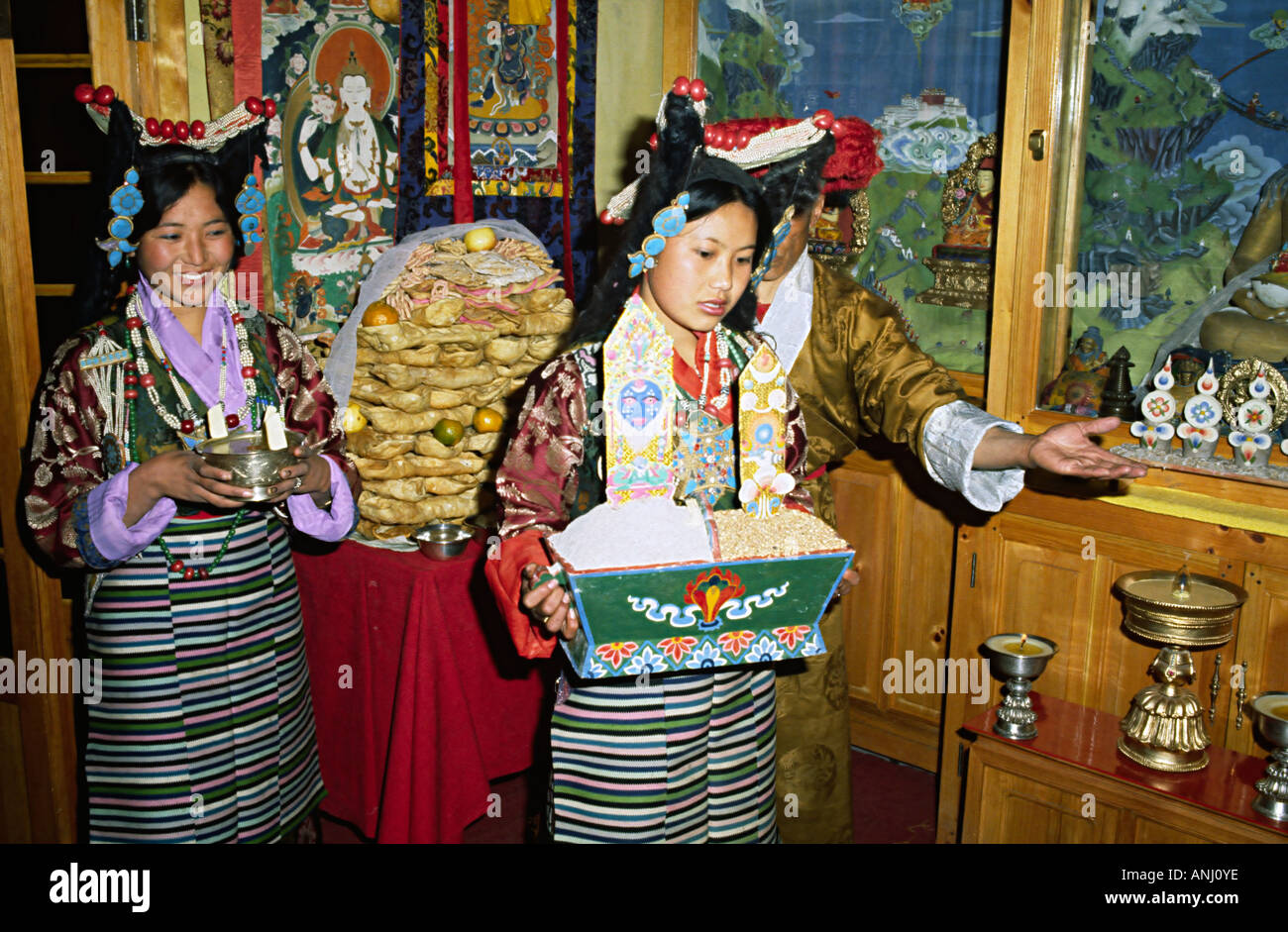 Des femmes membres de l'Insititute tibétain des arts de la scène dans une robe traditionnelle servant de la nourriture lors d'un banquet tibétain à Dharamsala, en Inde Banque D'Images