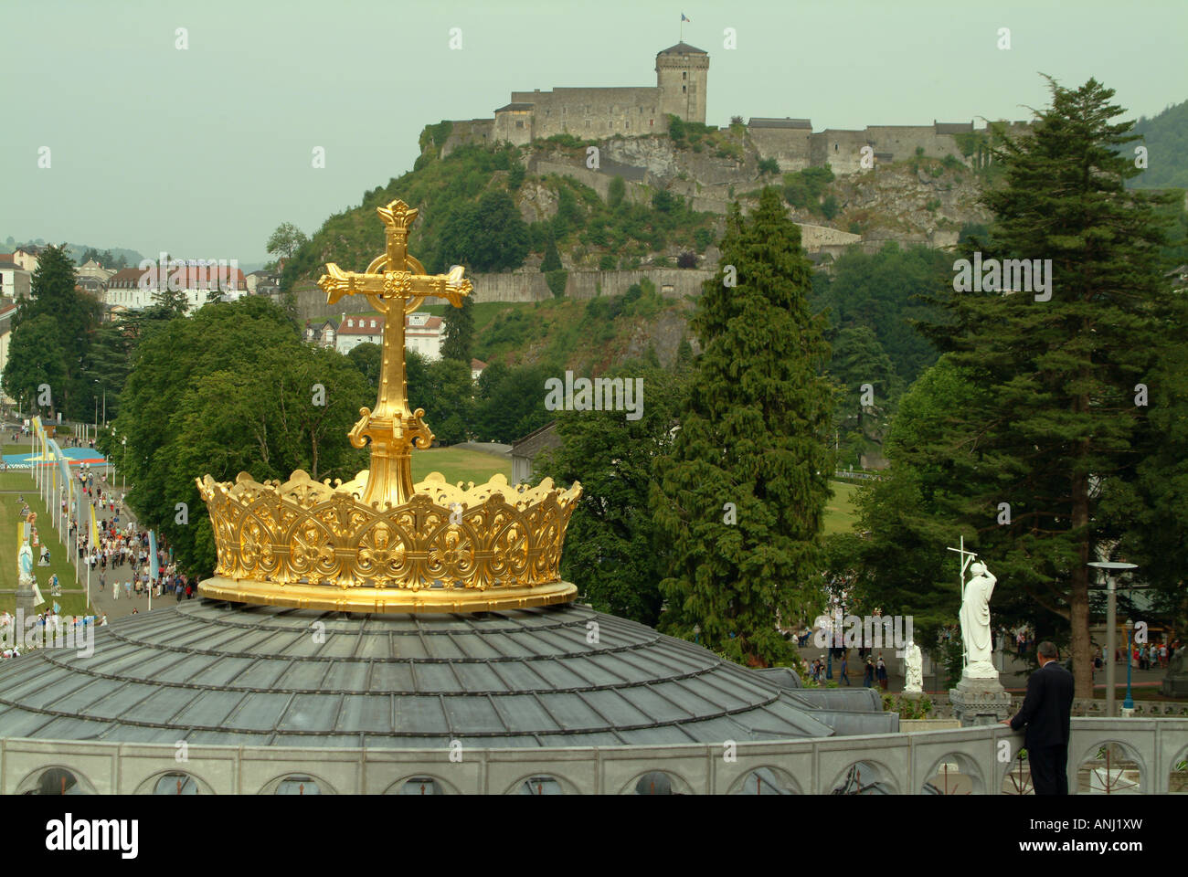 La croix d'or & couronne couronne sur le dessus de la basilique à coupole le château de lourdes est à l'arrière-plan Banque D'Images