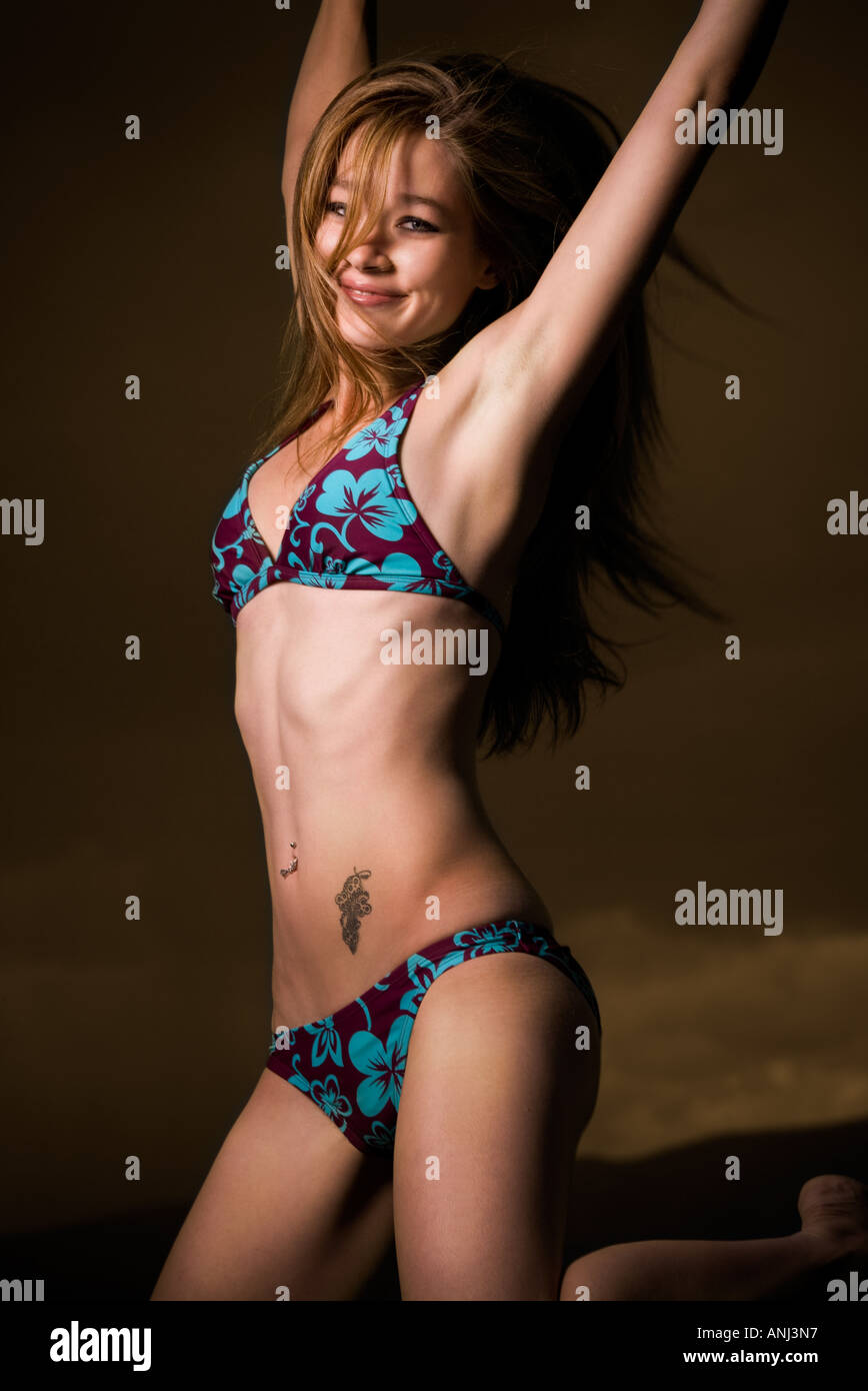 Portrait of a young woman in a bikini smiling and jumping Banque D'Images