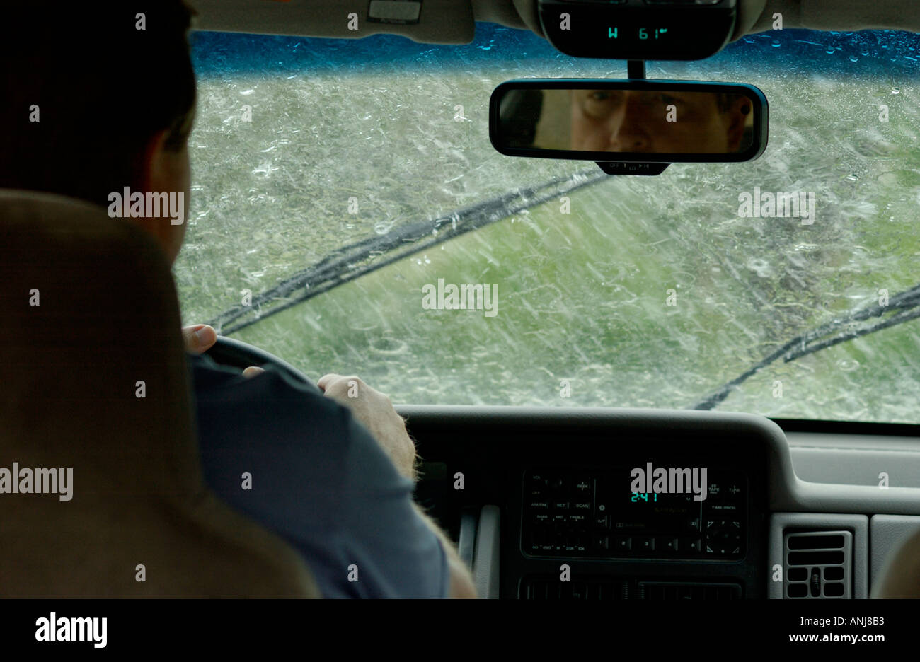 Businessman driving car dans la pluie Banque D'Images
