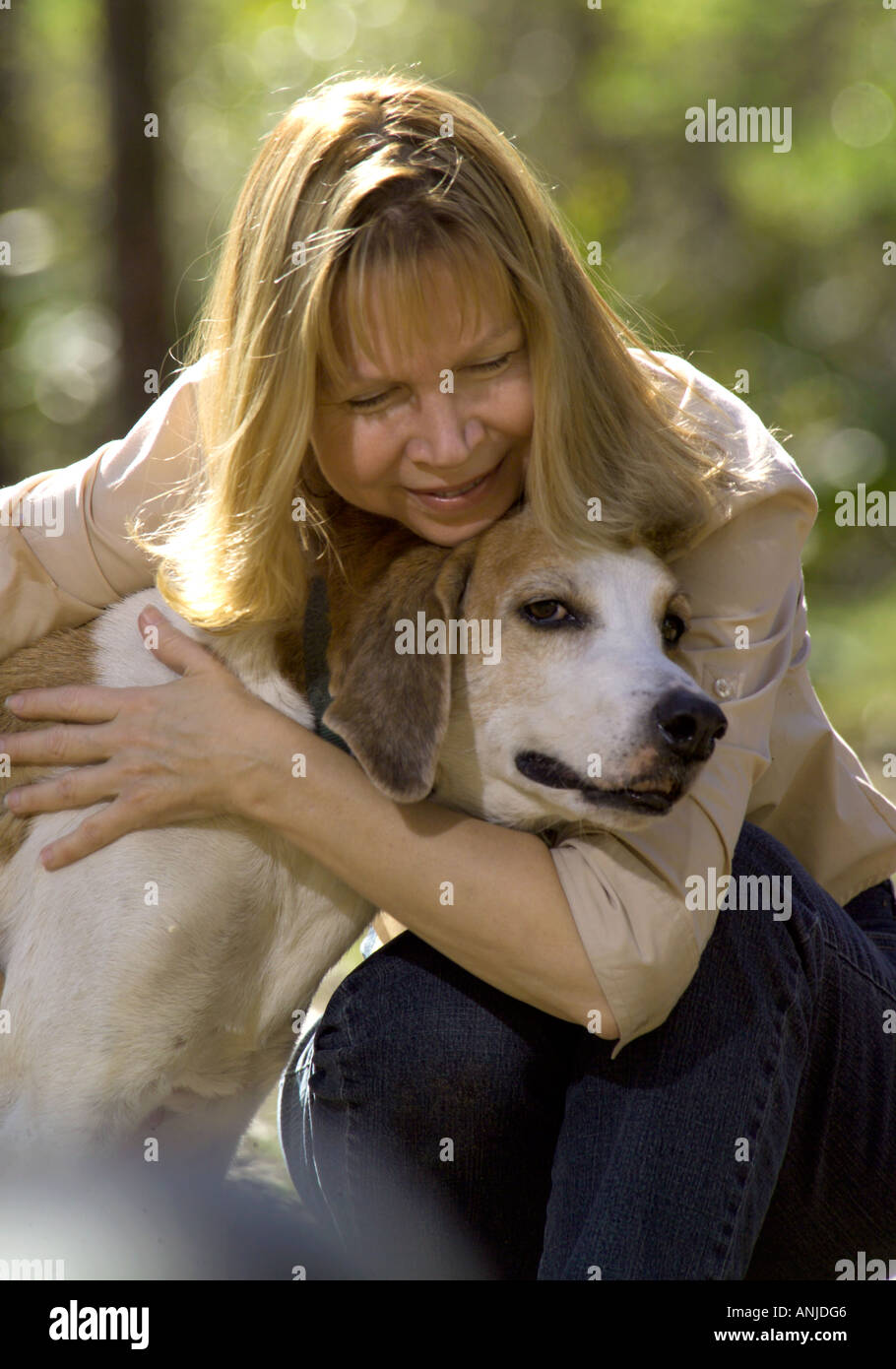 Young woman hugging dog Chien courant rétro extérieur Banque D'Images