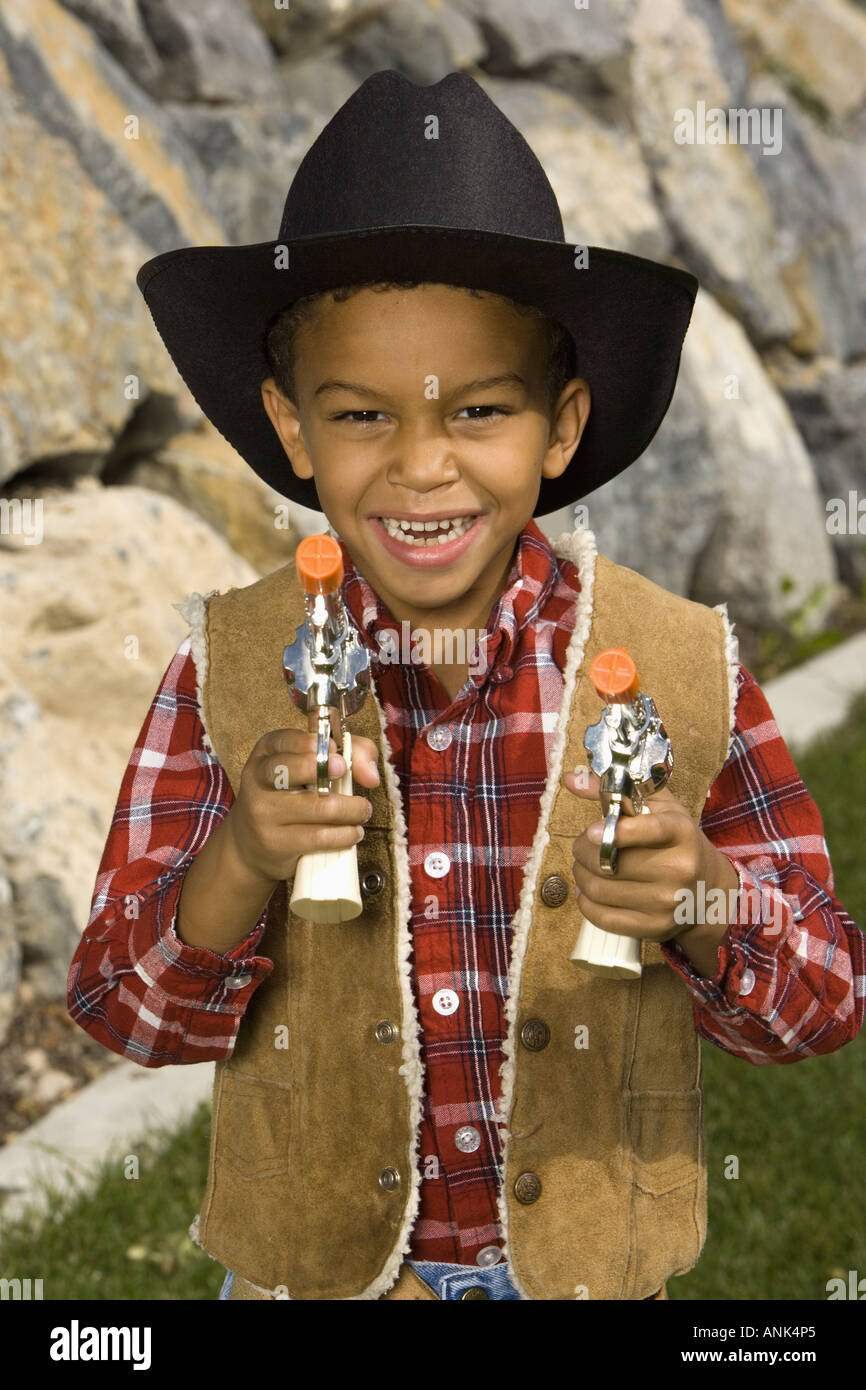 Portrait d'un garçon dans un costume de cow-boy holding a toy gun Photo  Stock - Alamy
