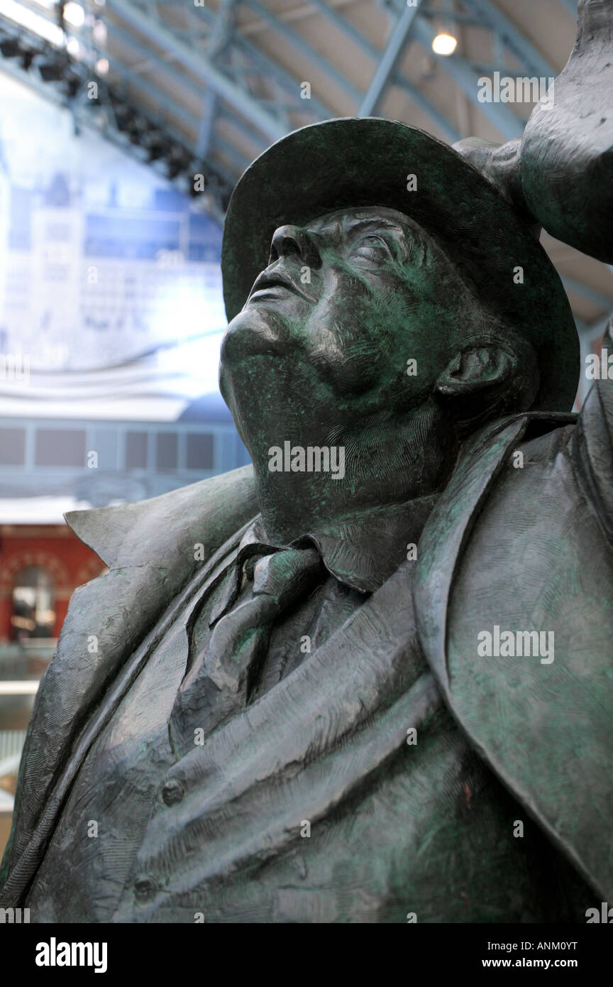 Une sculpture de Sir John Betjeman à jusqu'à l'émerveillement la splendeur de l'abri tout en catchining Barlow de tenir son chapeau Banque D'Images