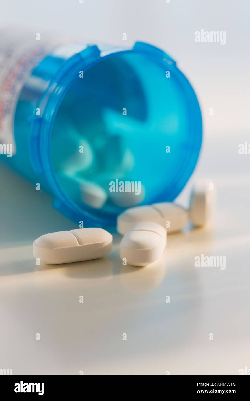 Close up of pills spilling out of bottle Banque D'Images